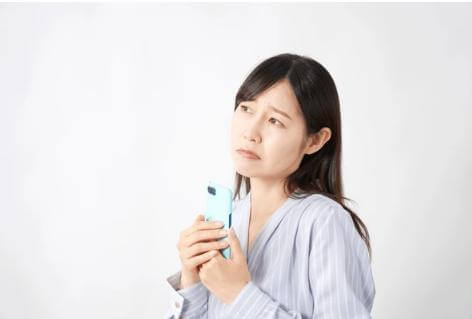 誰にも言えない気持ちを抱え、スマホで情報を探す40代女性