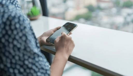 50代女性がスマホで女性用風俗を調べながら不安を感じている後ろ姿